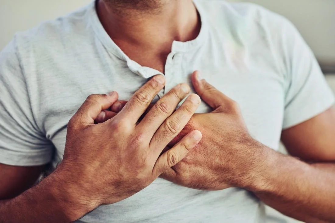 Person clutching chest, indicating chest pain
