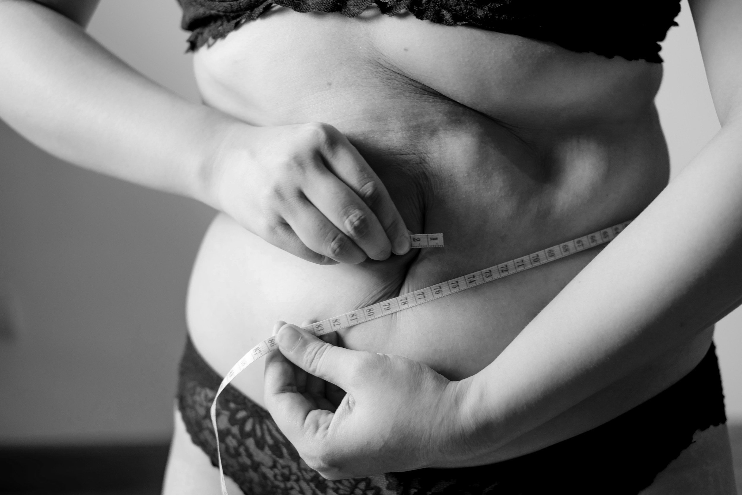 Measuring tape around a waist, black and white