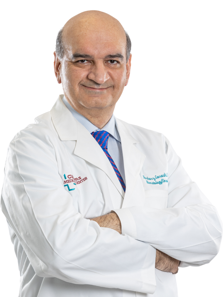 Dr. Fariborz Gorouhi, wearing a white coat with arms crossed