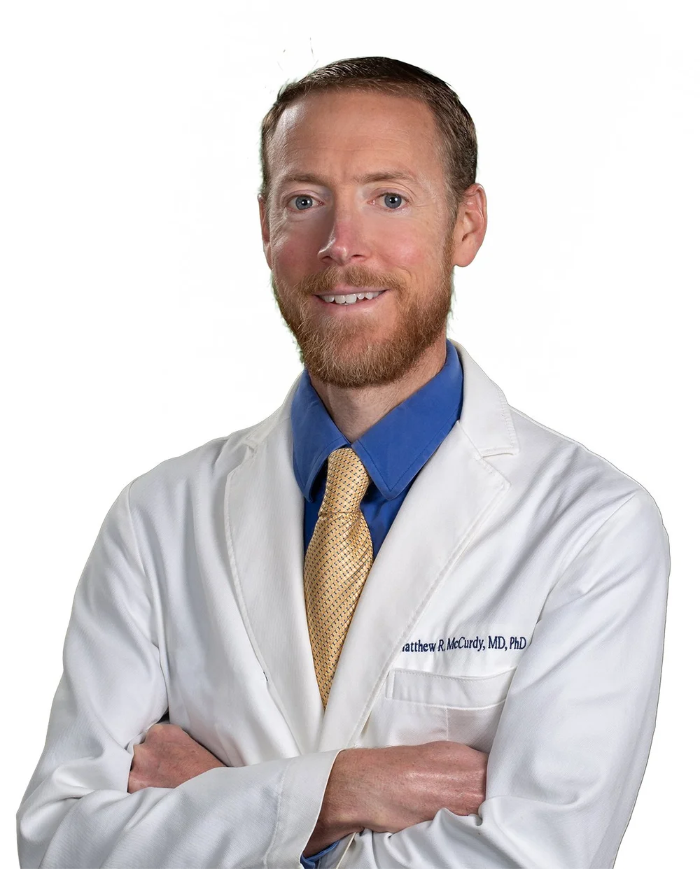 Dr. Matthew McCurdy, wearing a white coat over a blue shirt and gold tie