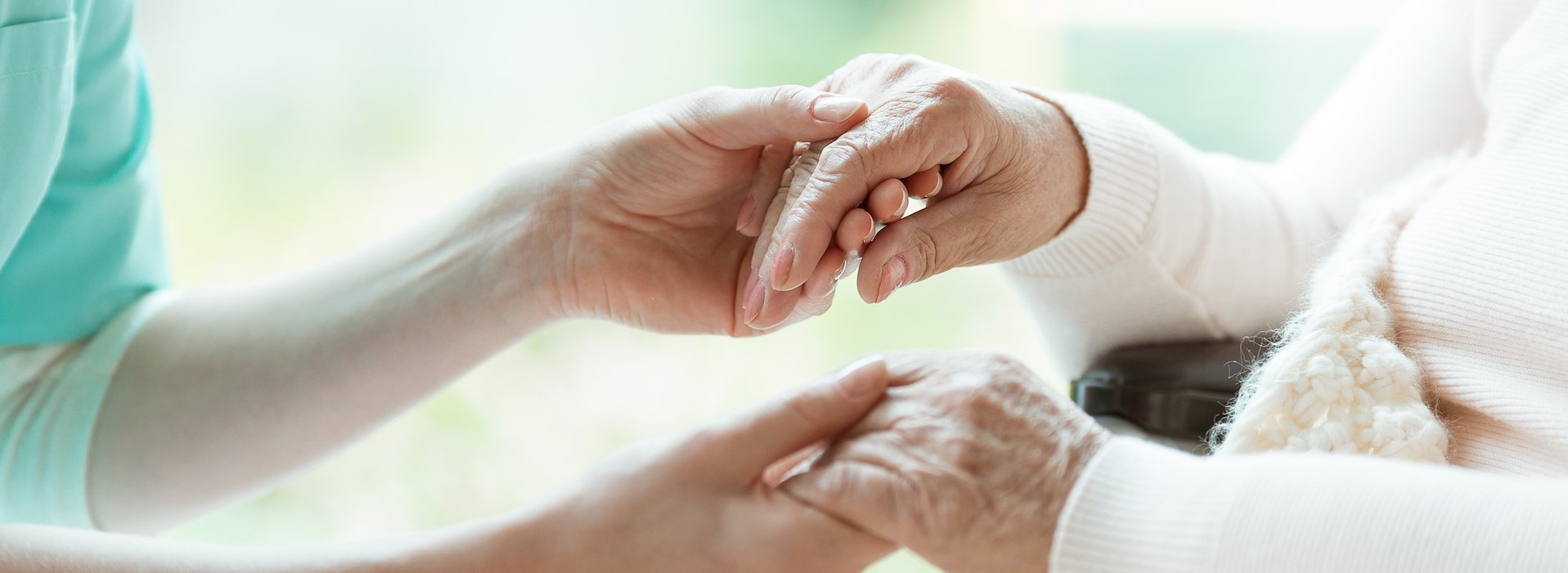 Caregiver holding an older patient's hands