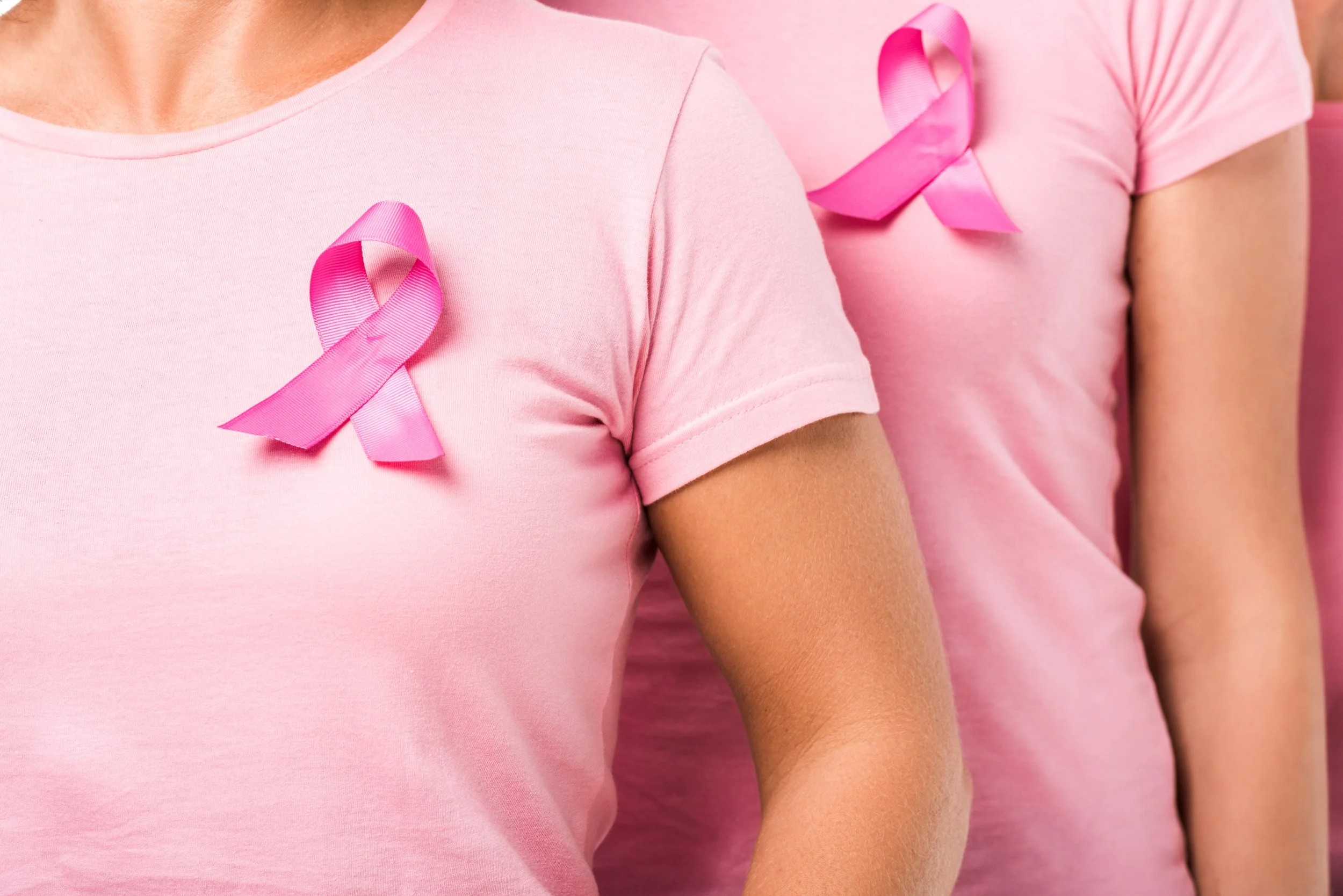Women wearing pink t-shirts with breast cancer awareness ribbons